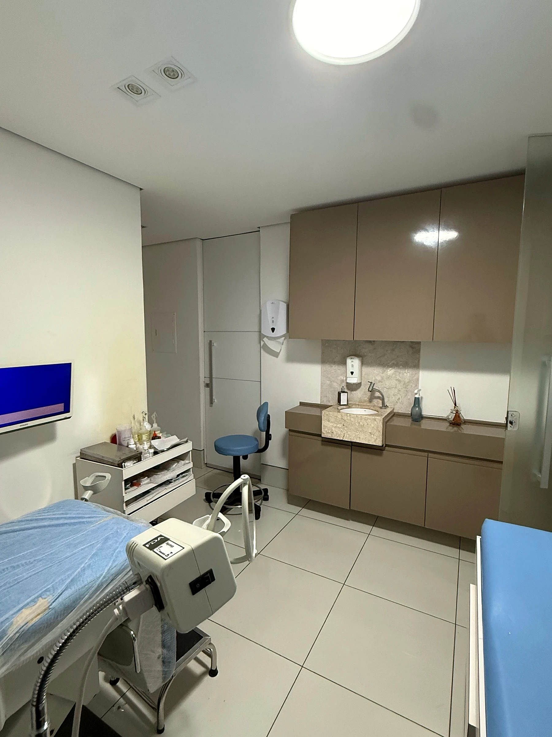 Sala de exame físico do consultório com equipamentos e bancada clínica